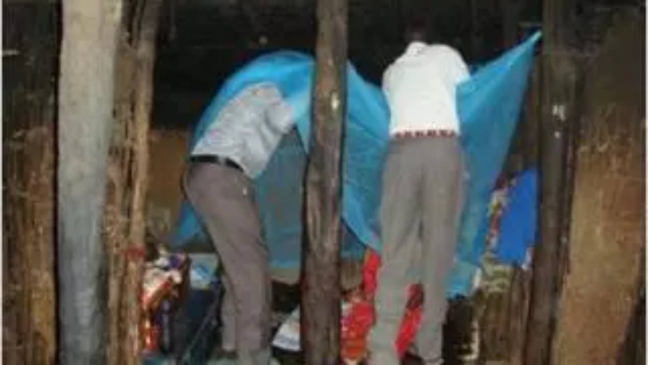 Two men setting up a mosquito net. PHOTO/COURTESY